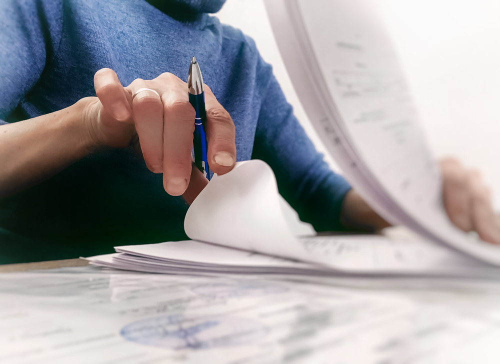 Person reviewing and organizing business documents carefully.