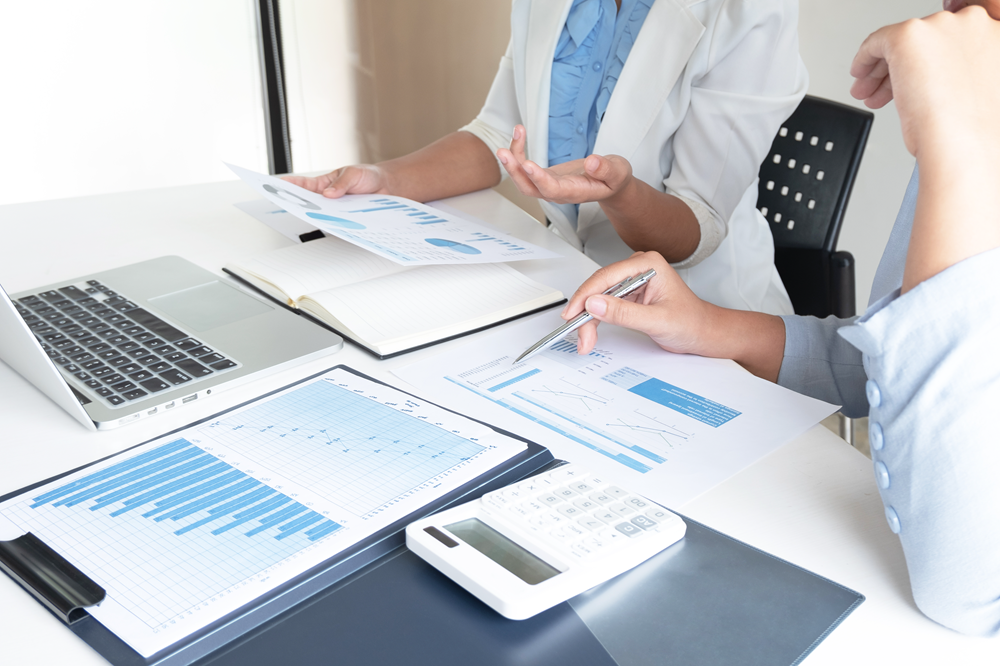 Business meeting analyzing financial data and charts.