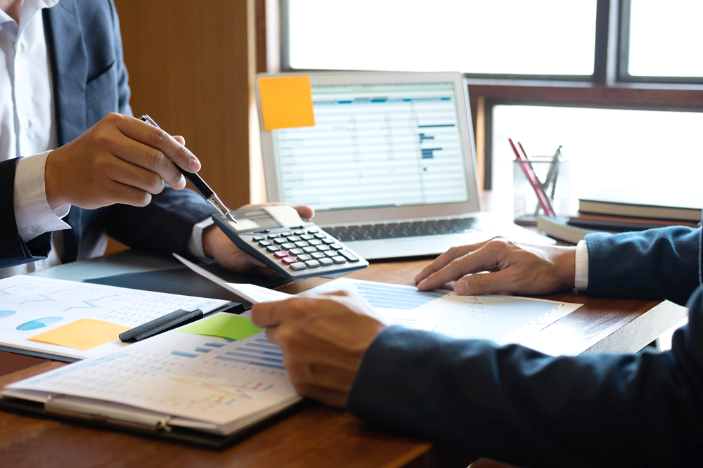 Business meeting discussing financial documents and calculations.