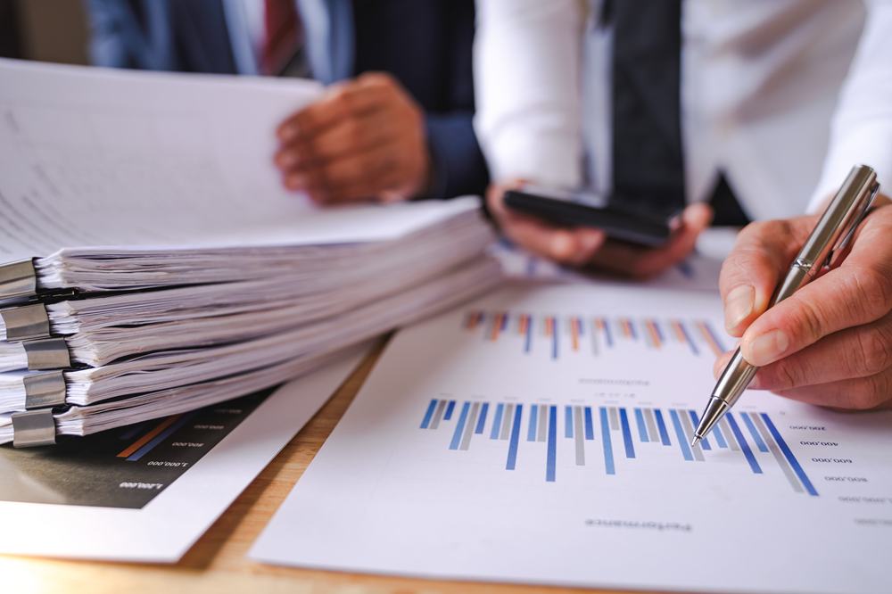 Business analysis with graphs and documents on table