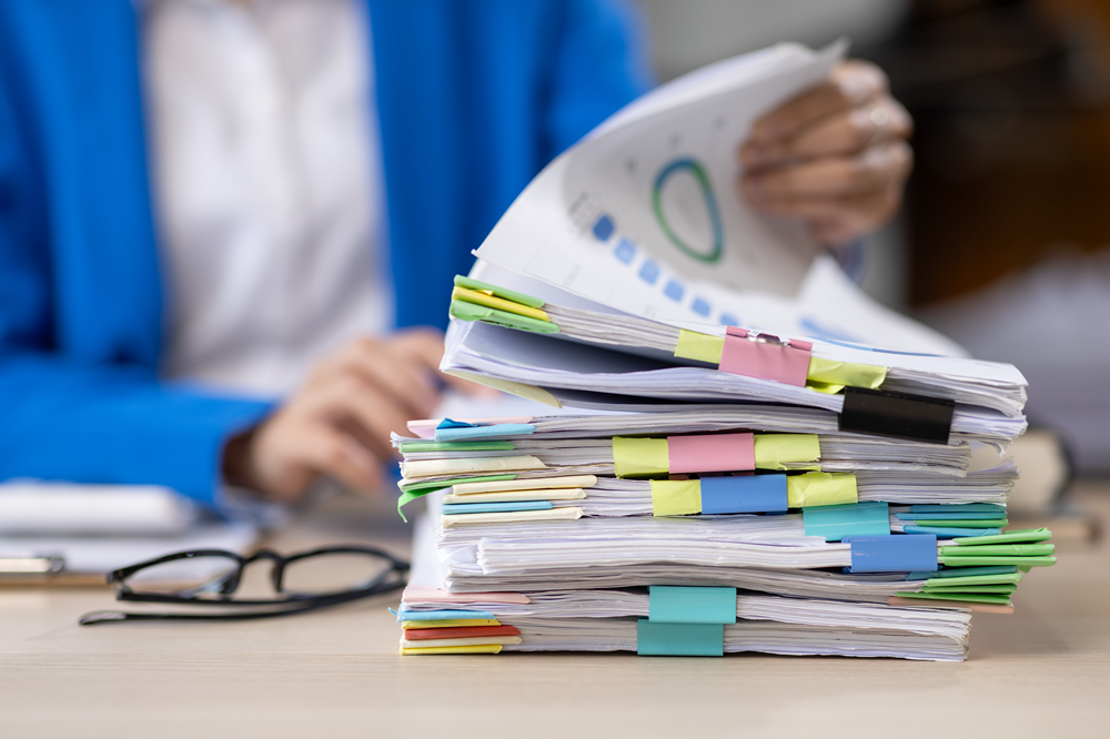 Stacks of organized documents with paperclips on desk
